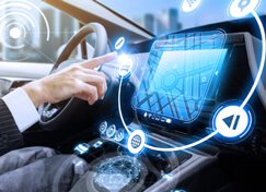 hand in car reaching for touch screen in car dashboard