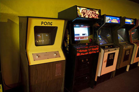 A vintage Pong arcade game next to other arcade games. Source: Wikimedia