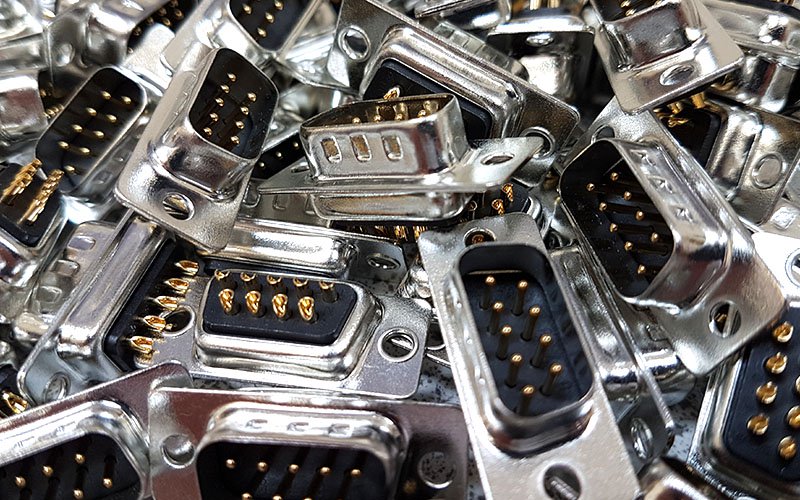 A pile of silver and black VGA connectors with gold pins.
