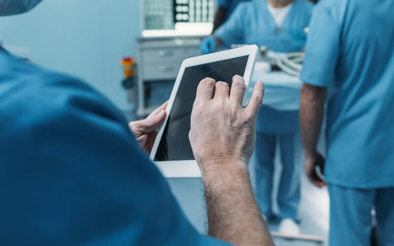 medical personnel and one is using a tablet