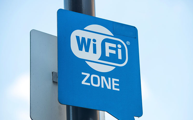 A blue sign labeled ZONE with a white Wi-Fi symbol is mounted on a pole.