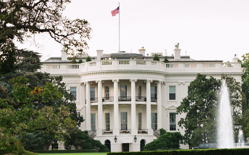 The White House, surrounded by lush greenery and a beautiful fountain.