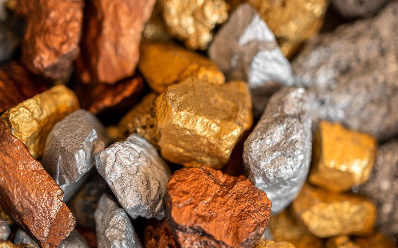 A close-up of a pile of gold, silver, and bronze nuggets.