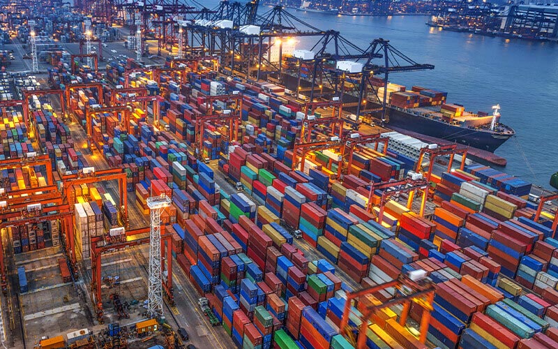 Shipping yard full of shipping containers and some cargo ships