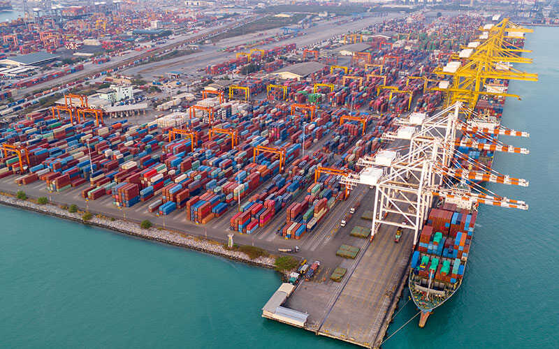 aerial view of a busy container ship terminal with hundreds of stacked containers
