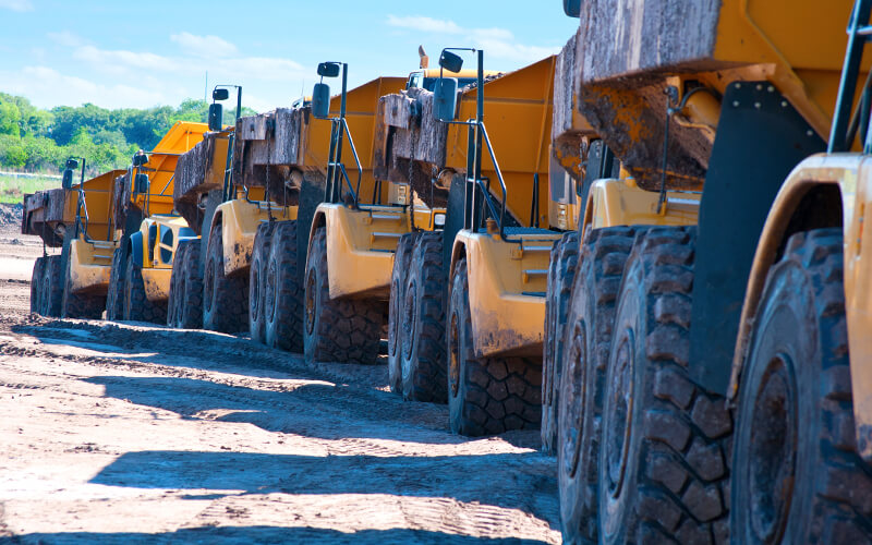 Large muddy dump trucks lined up